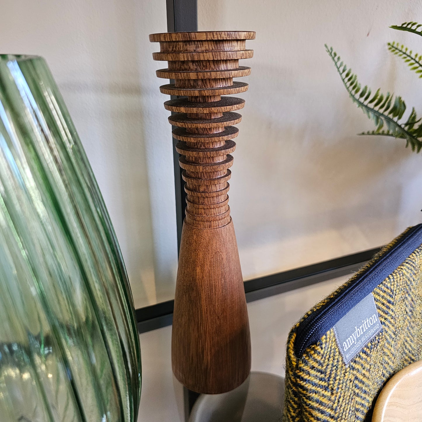 A unique, handcrafted wooden vase in different tapered and ribbed showing the natural wood grain and high-quality finish.