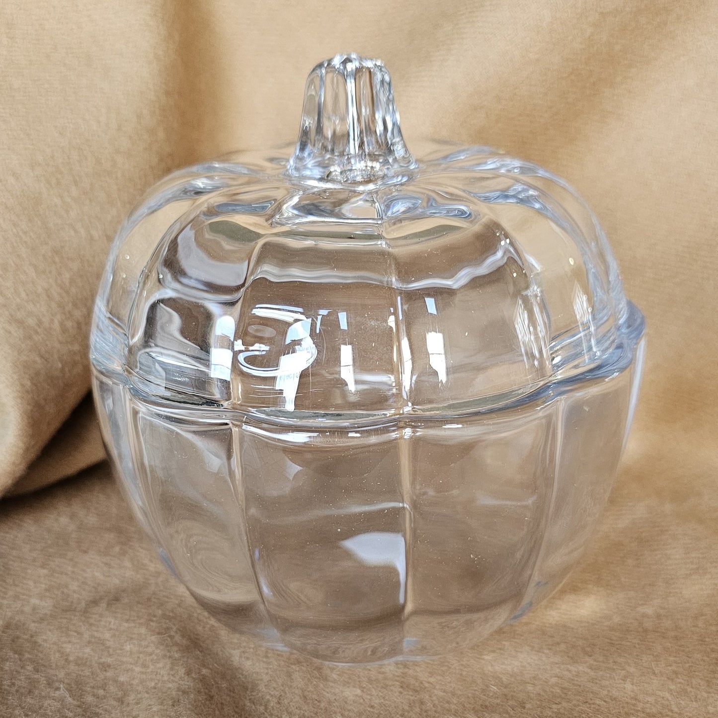 Glass pumpkin-shaped jar, ideal for storage or autumn decoration.