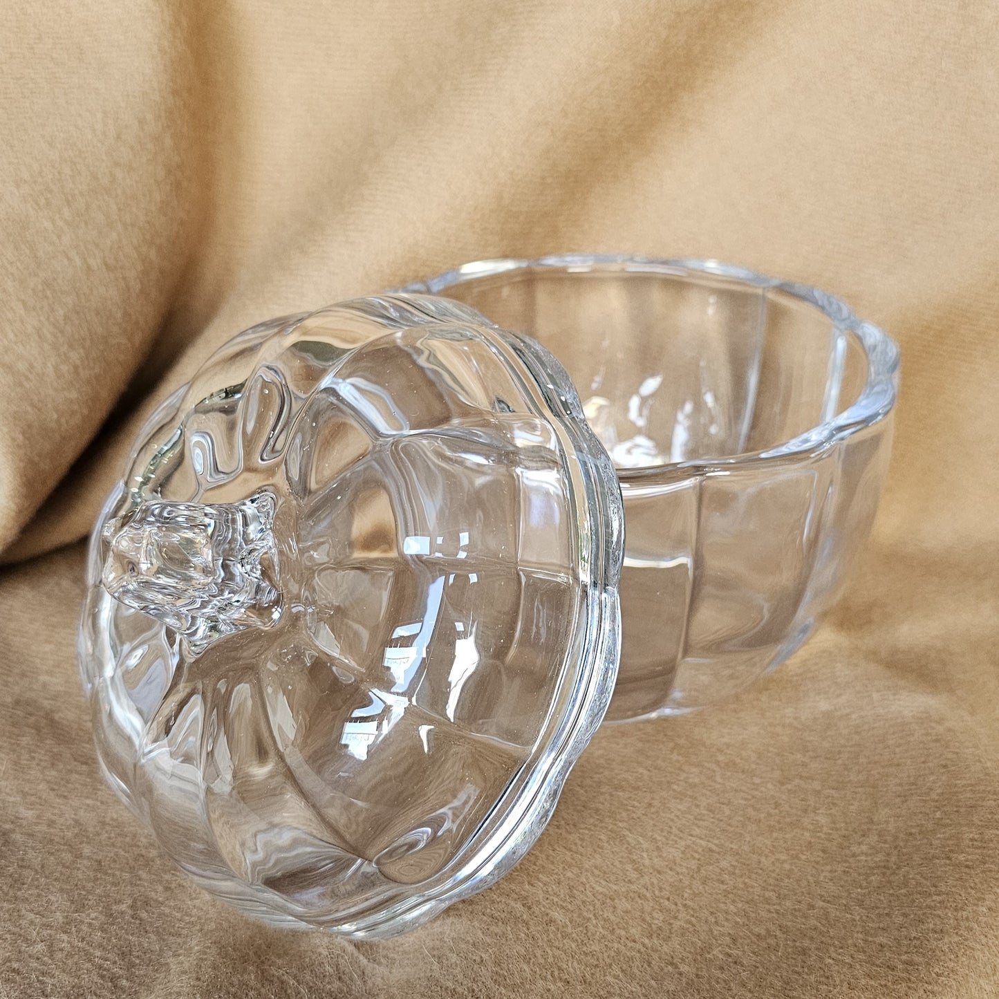 Glass pumpkin-shaped jar, ideal for storage or autumn decoration.