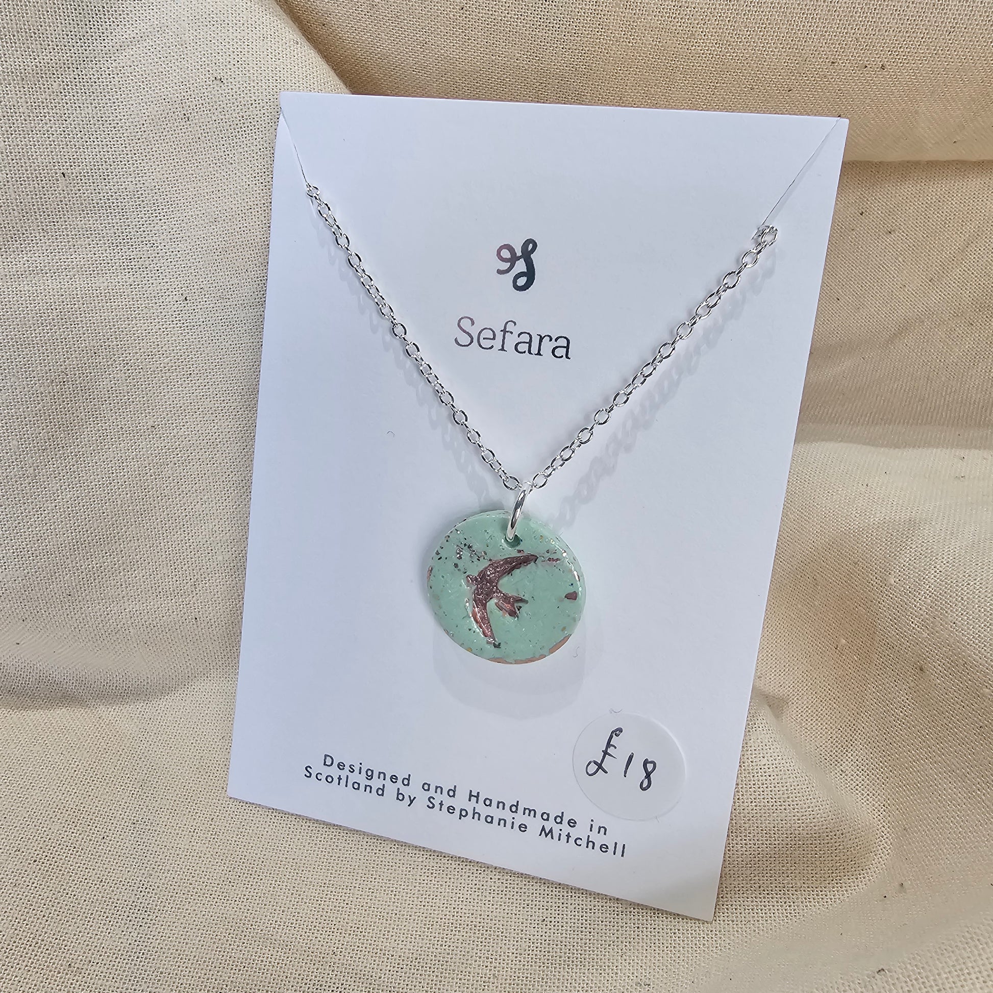 Handmade aqua polymer clay circle pendant on 18-inch silver chain by Sefara Jewellery. Swallow design.