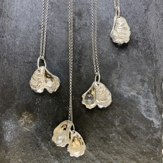 Double sterling silver oyster shell pendants on 18-inch chains showing the unique pearls inside.