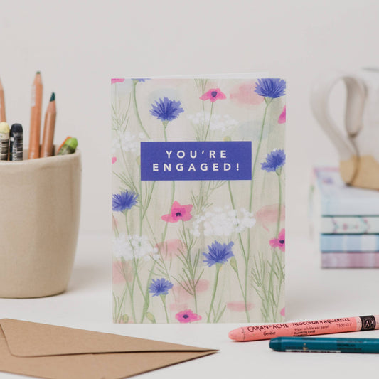 Luxury A6 engagement card with 'you're engaged!' text and blue, white, pink flower illustration, blank inside, printed on 350gsm UK card