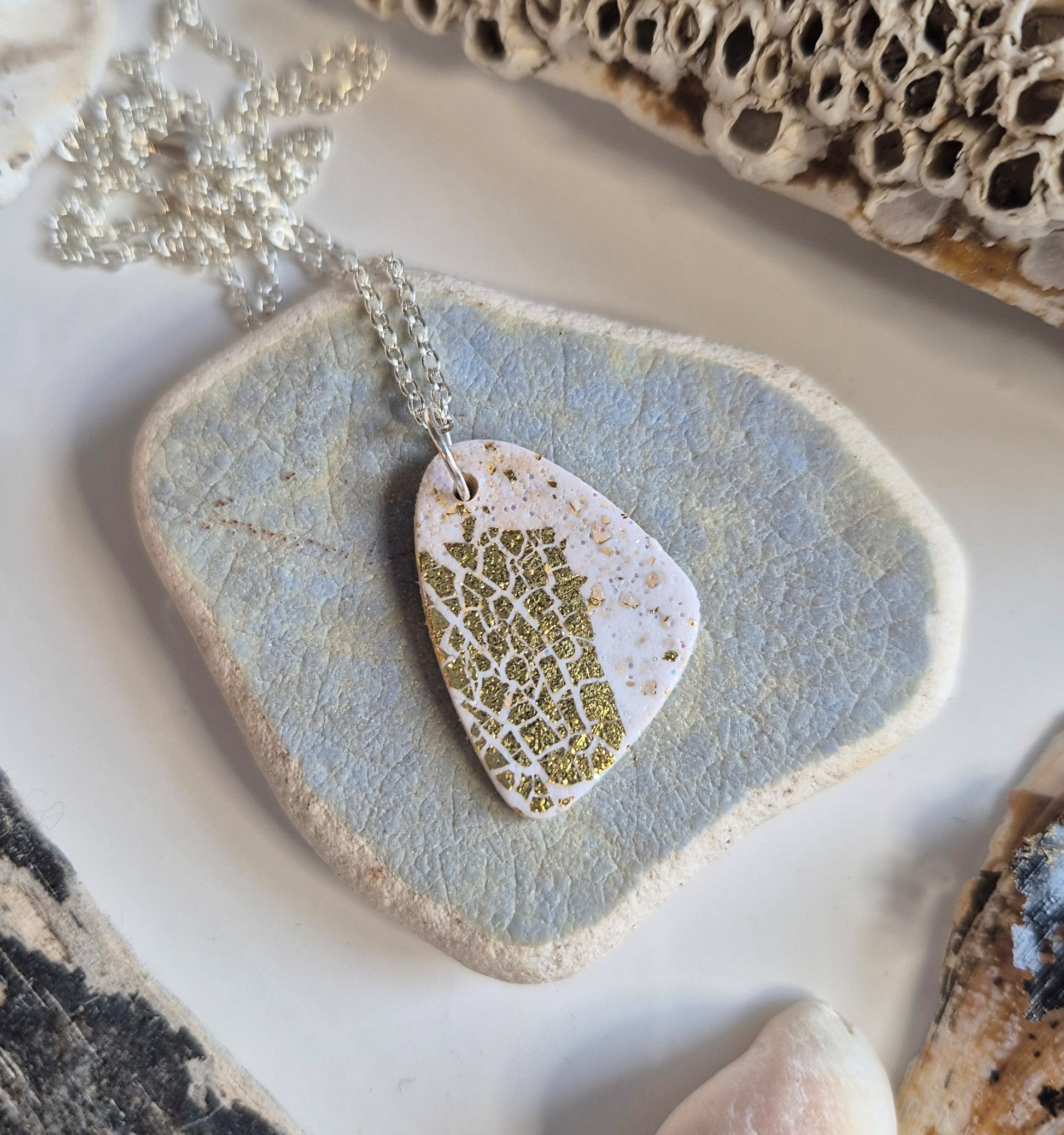 Handmade cream polymer clay pebble shaped pendant on 18-inch silver chain by Sefara Jewellery. Gold leaf design.
