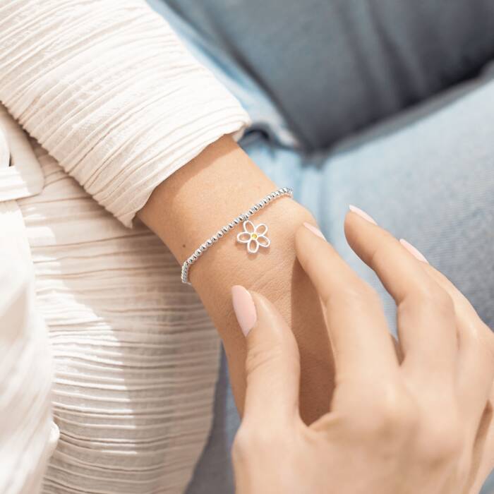 A silver bracelet with a small decorative flower charm. This sparkling bracelet is just for you to say you're special through and through.