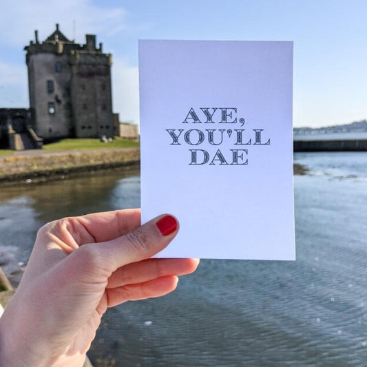 A vertically folded greeting card with the Scottish phrase "Aye You'll Dae" in modern, hand-designed typography.