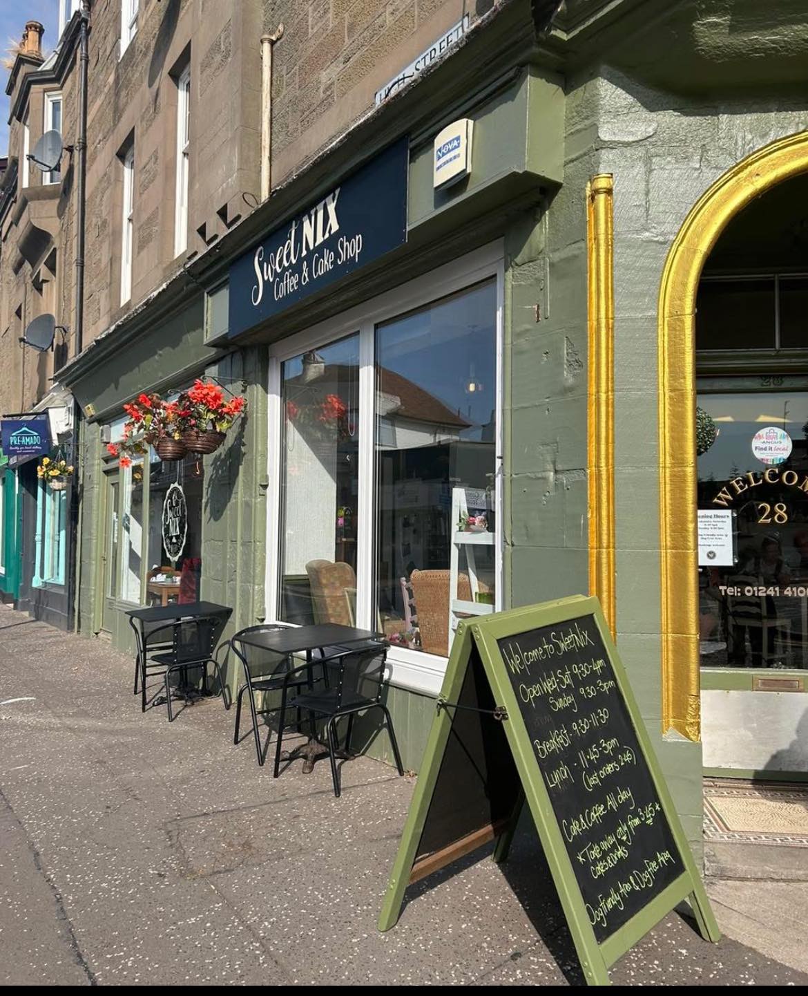 Street view of a cafe named 'Sweet Nix' with outdoor seating and a chalkboard sign.