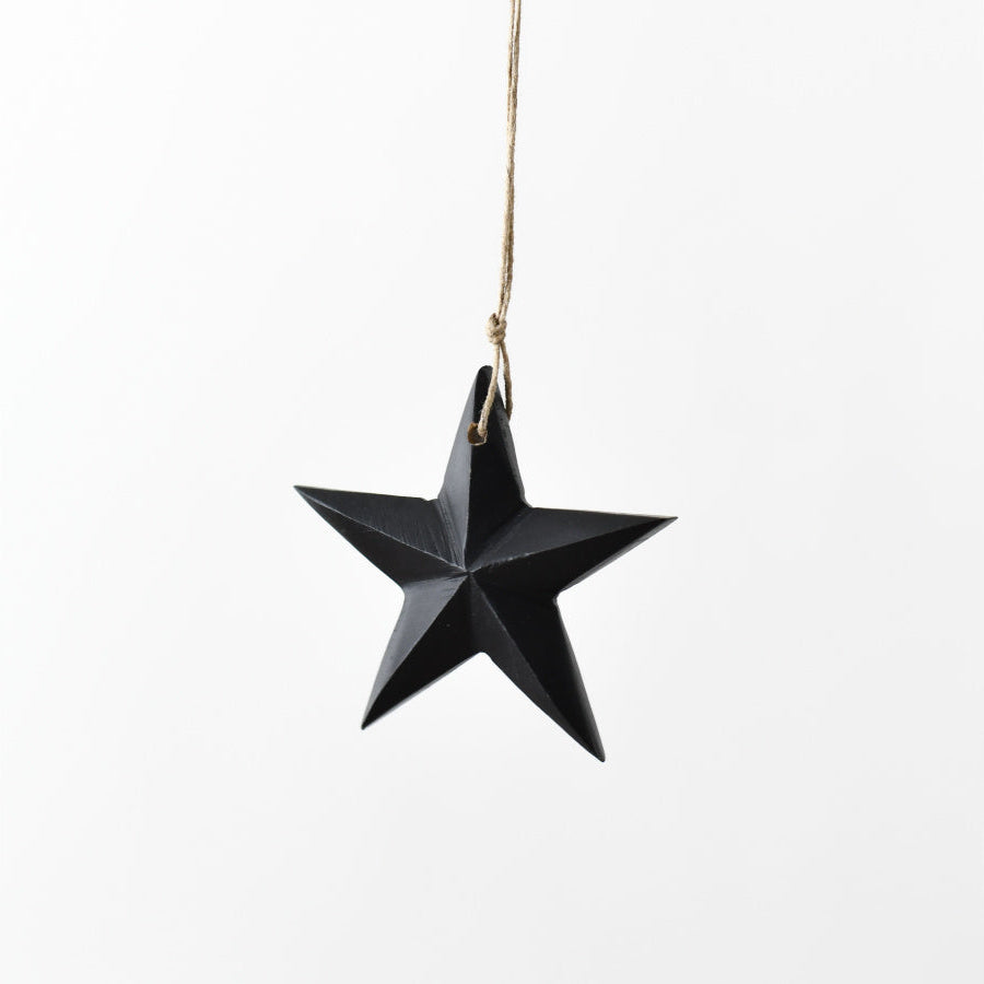 A sleek star-shaped decoration made from black mango wood with a jute string for hanging.