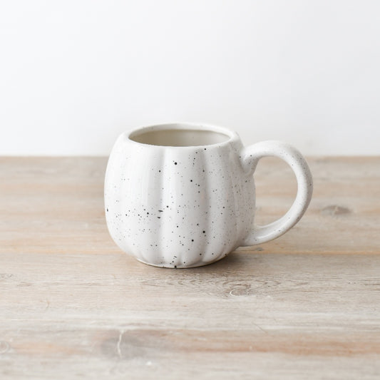 White speckled ceramic pumpkin-shaped mug, ideal for autumn drinks.