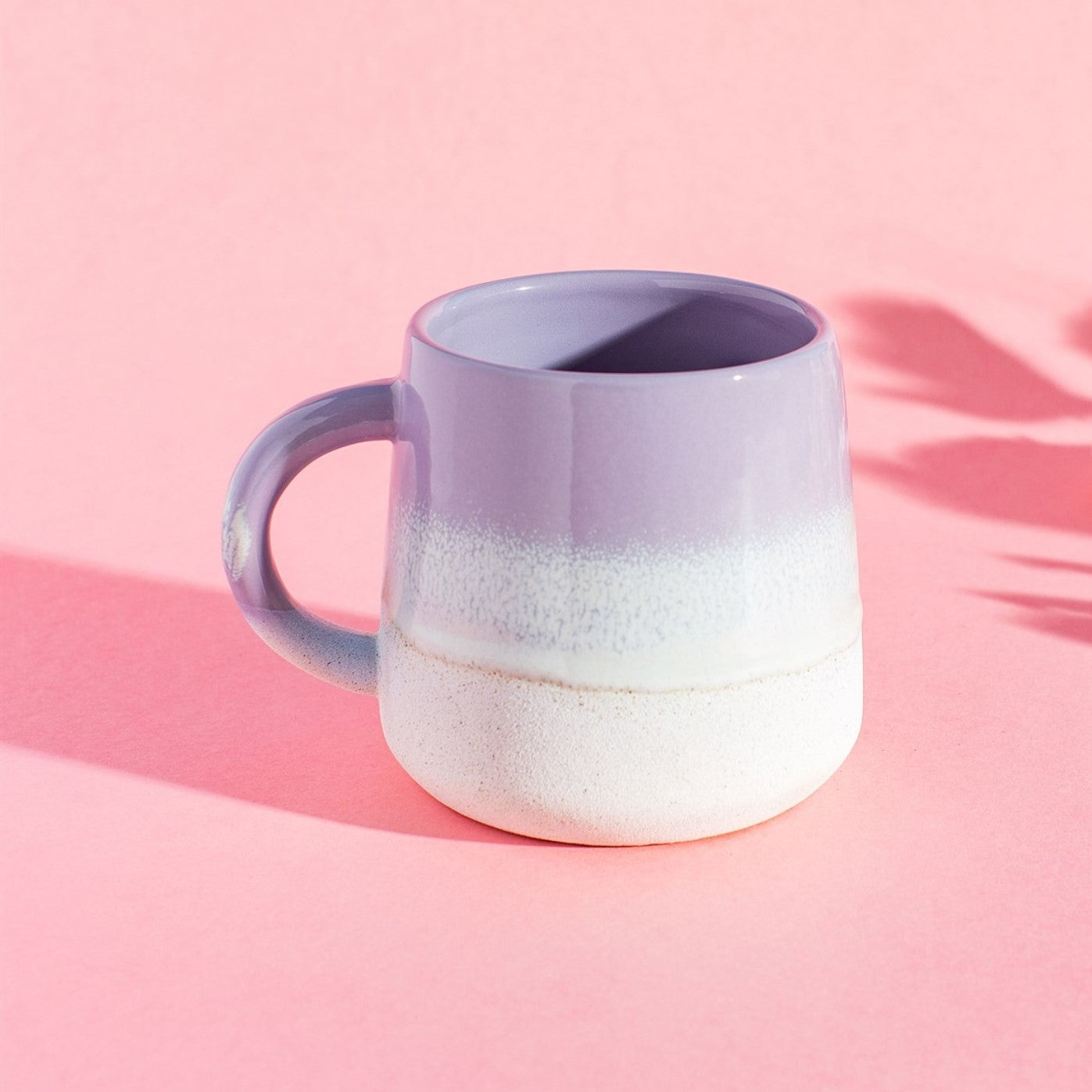 A stoneware mug featuring a lilac ombre colour transition achieved with a reactive glaze, approximately 13.5cm wide and 10cm high.