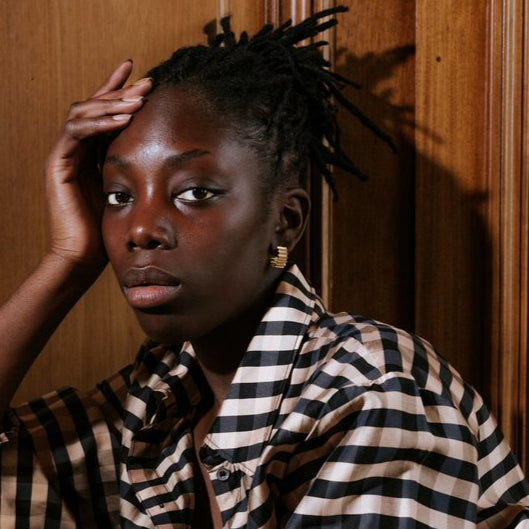 Woman in a striped outfit wearing the
MAD Ondulée Hoop handmade in Glasgow from recycled sterling silver – bold, wearable and exclusive in design