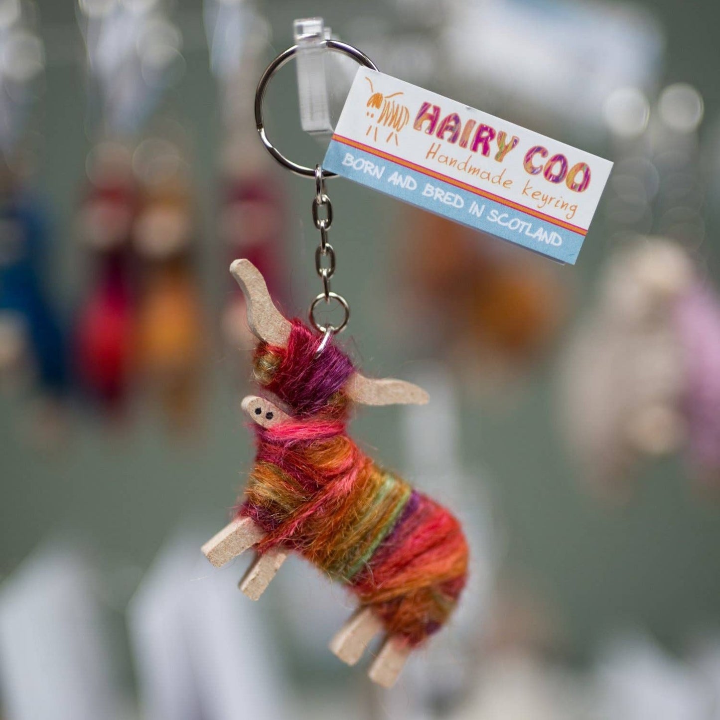 A handcrafted Hairy Coo keyring in the shape of a Highland cow wrapped in hand-dyed mohair