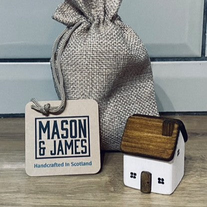 Handcrafted white wooden cottage ornament with distressed nautical finish in jute drawstring bag