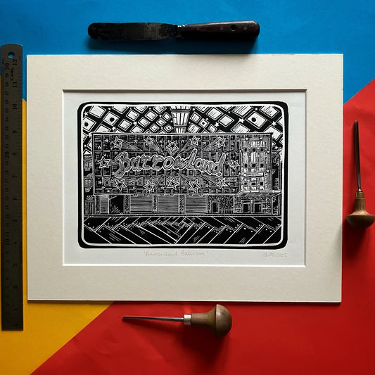 An original black and white linocut print of the iconic Barrowland Ballroom in Glasgow, mounted on antique white card.