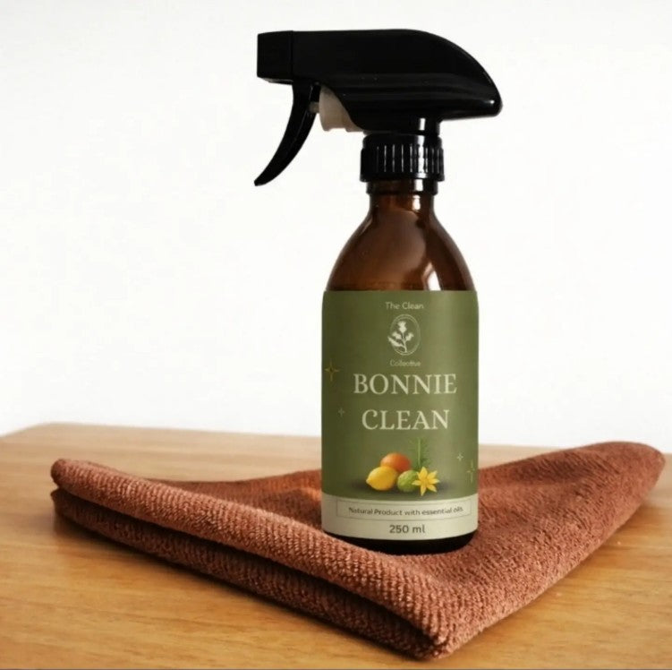 Bonnie Clean natural all purpose spray bottle cleaner with rosemary lemon and tea tree fragrance made in Scotland with a cleaning cloth on a wooden surface