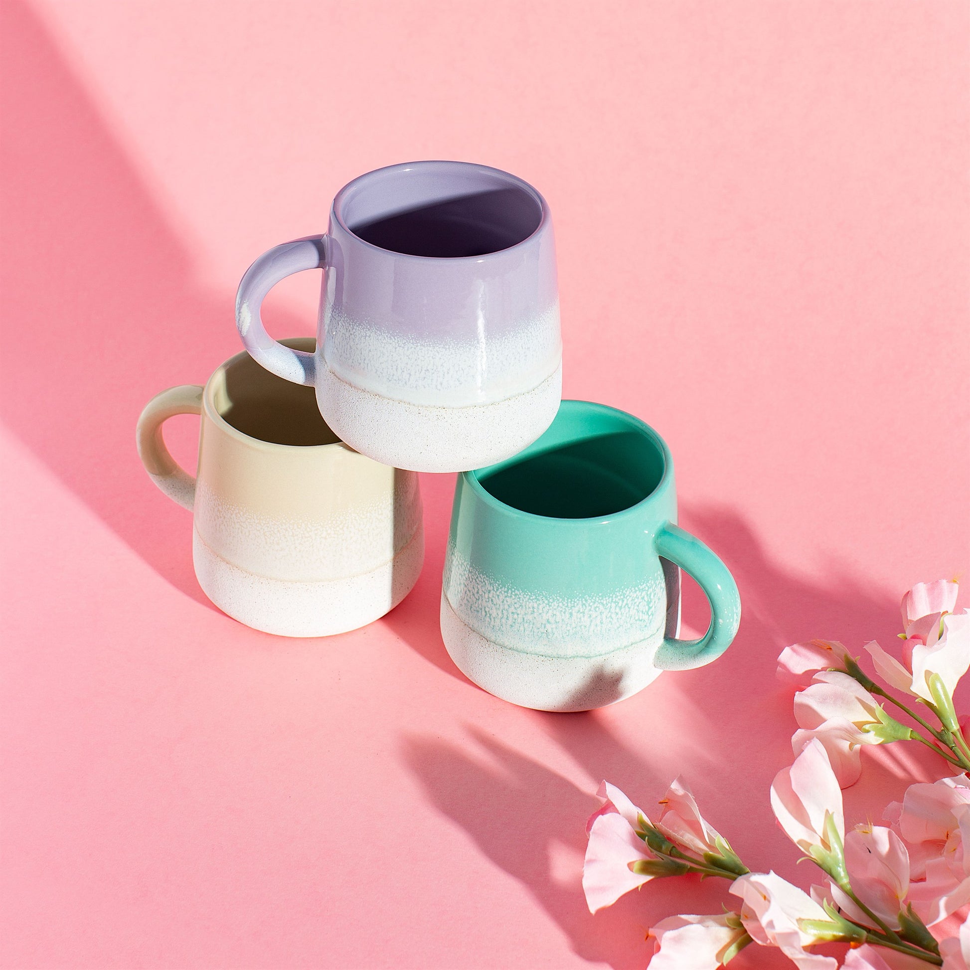 Stoneware mugs featuring ombre colour transition achieved with a reactive glaze, approximately 13.5cm wide and 10cm high.