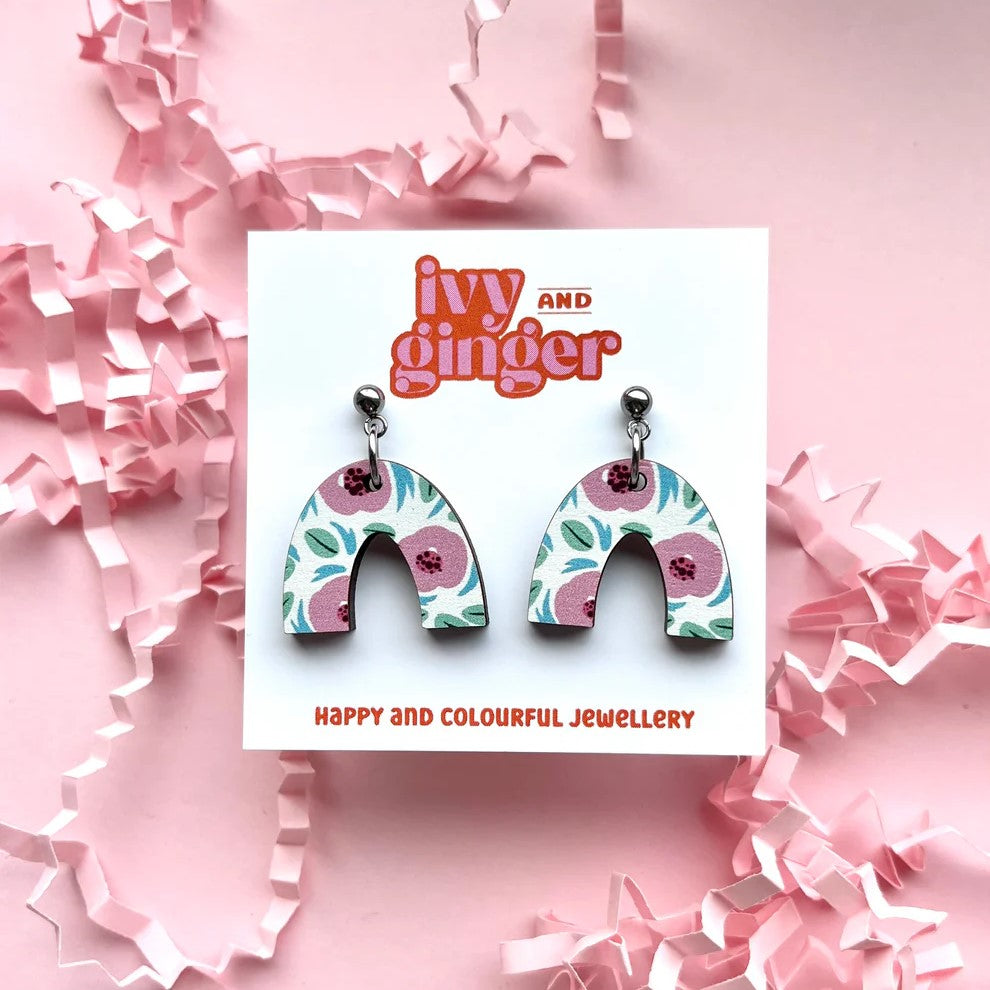 Floral arch-shaped earrings on a 'Ivy and Ginger' branded card with pink confetti background