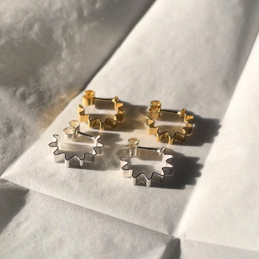 Close-up of the Mini Ondulée Hoop earring by Olivia Taylor, handmade in Glasgow from recycled 925 sterling silver. A small, sculptural huggie-style hoop with a wave design.