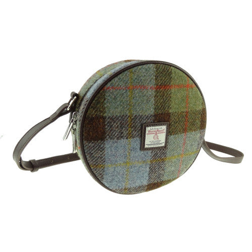 Classic compact round shoulder bag made from genuine Harris Tweed wool, featuring a zip closure, adjustable strap, and faux leather trim.