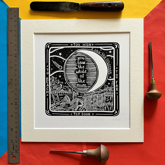 An original black and white linocut print featuring imagery inspired by The Waterboys song 'The Whole of the Moon', mounted on antique white card.