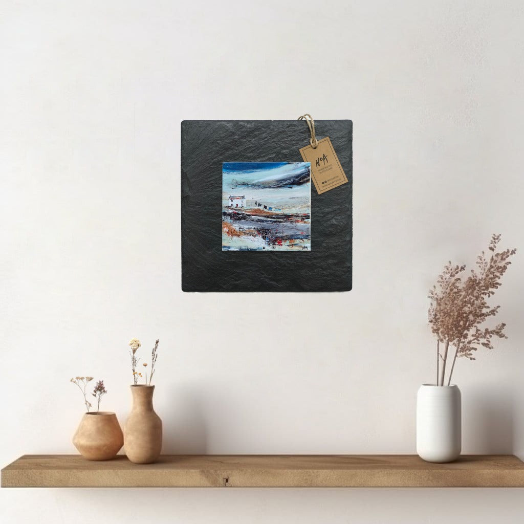 A ceramic tile print of a colourful painting titled 'Road to the Shee', showing a small house nestled in the Scottish Highlands, available mounted on natural slate or framed.