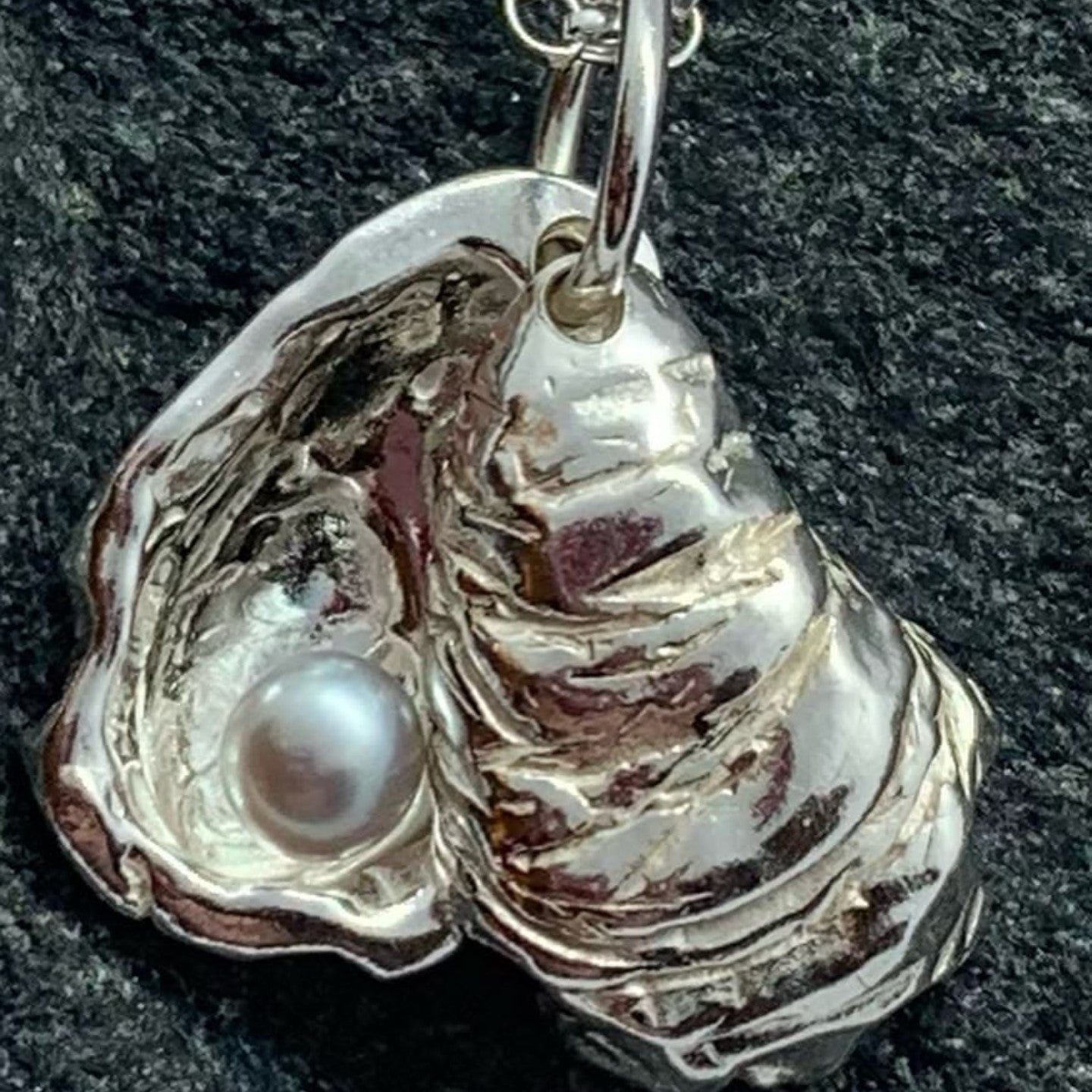 Close-up of double sterling silver oyster shell pendant on an 18-inch chain showing the unique pearl inside.