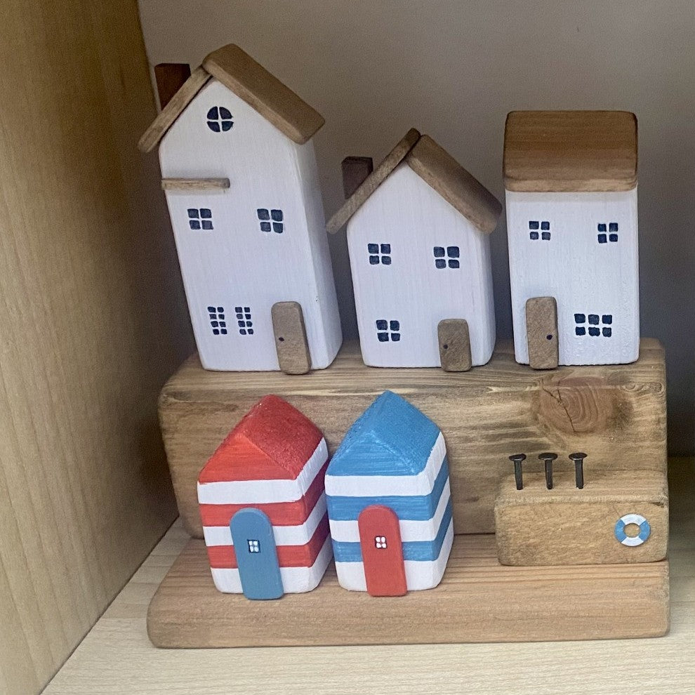 Handcrafted seaside village with three white houses and colourful beach huts in nautical distressed style