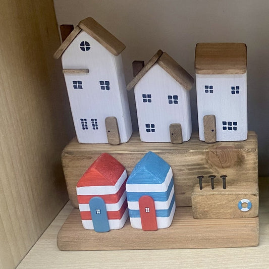 Handcrafted seaside village with three white houses and colourful beach huts in nautical distressed style