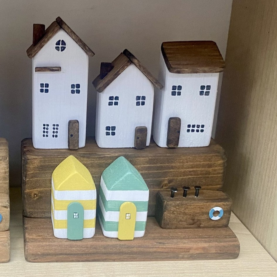 Handcrafted seaside village with three white houses and colourful beach huts in nautical distressed style