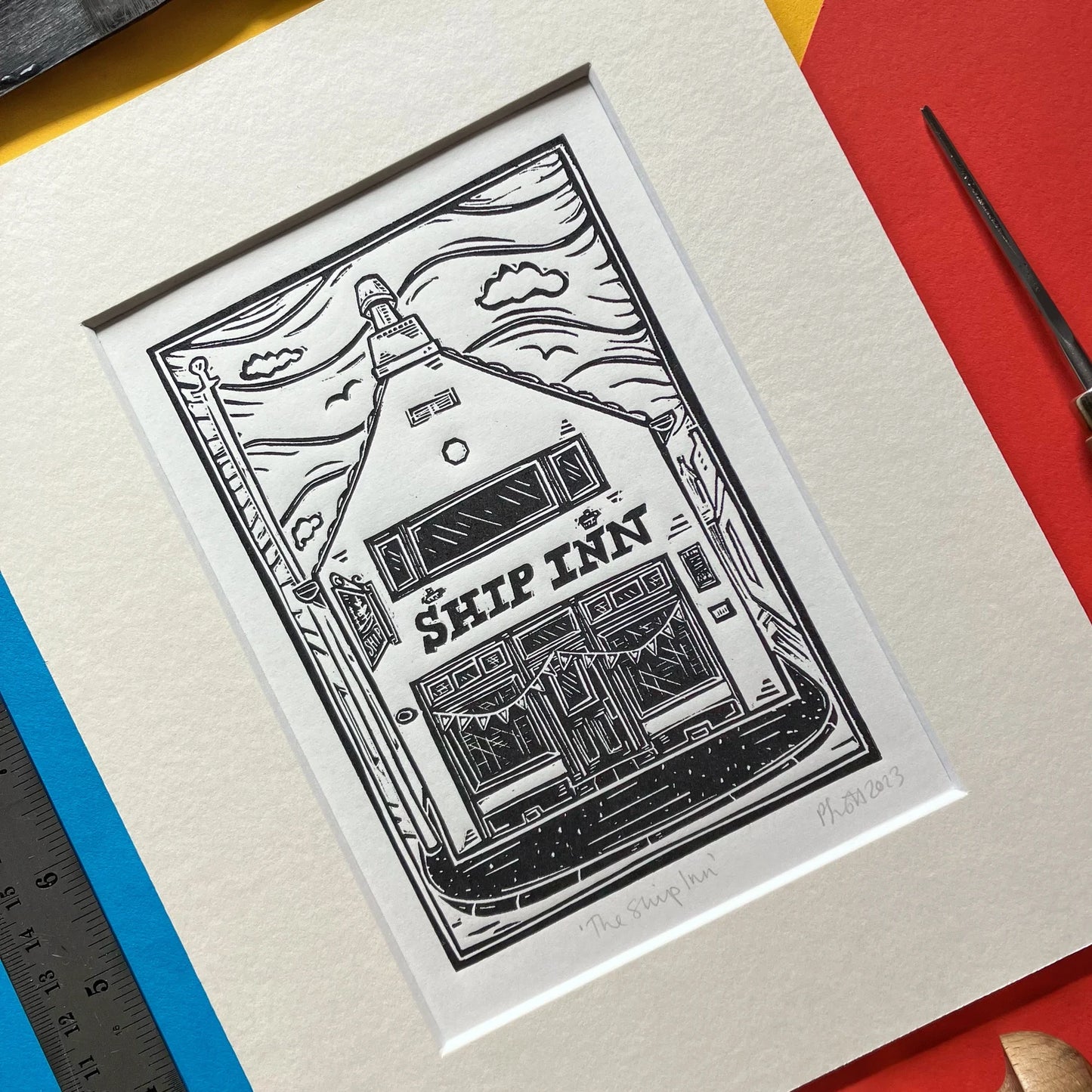 Black-and-white linocut of The Ship Inn pub in Broughty Ferry, Dundee, hand-printed by Pamela Scott, mounted in antique white.