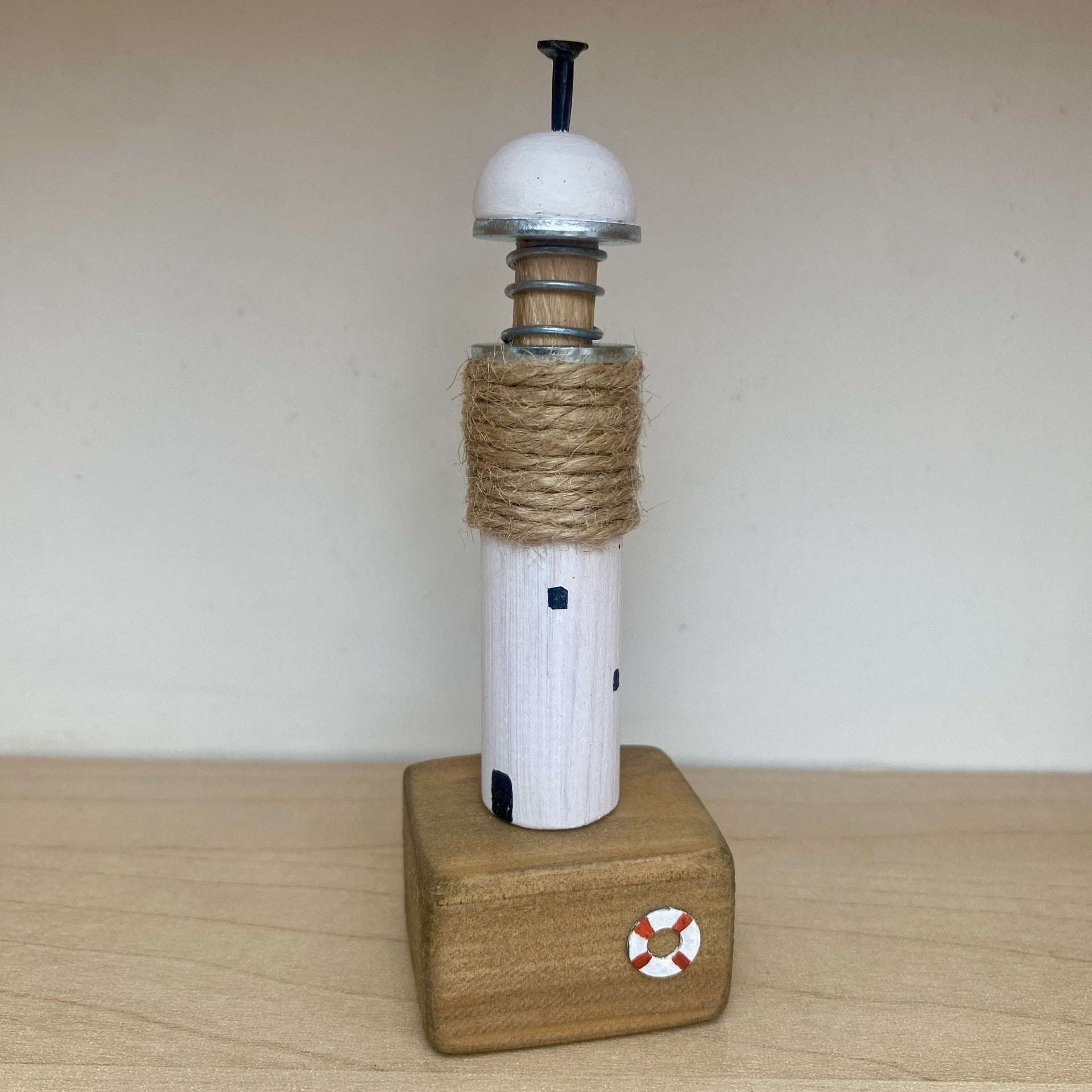 Handcrafted wooden lighthouse ornament with rustic metal and rope details in White/Twine