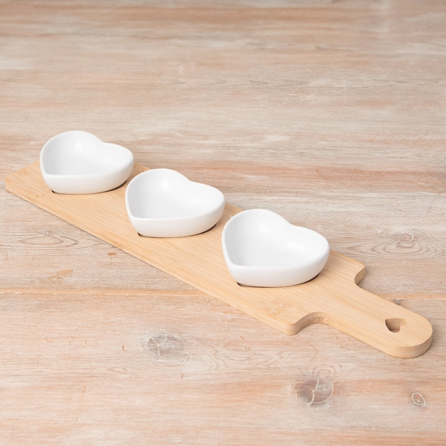 Wooden snack tray with three ceramic heart-shaped dishes for serving snacks and dips