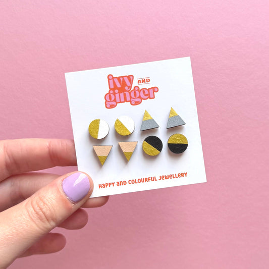 Set of four monochrome and gold stud earrings in triangle and circle shapes, handmade from FSC wood with surgical steel posts.