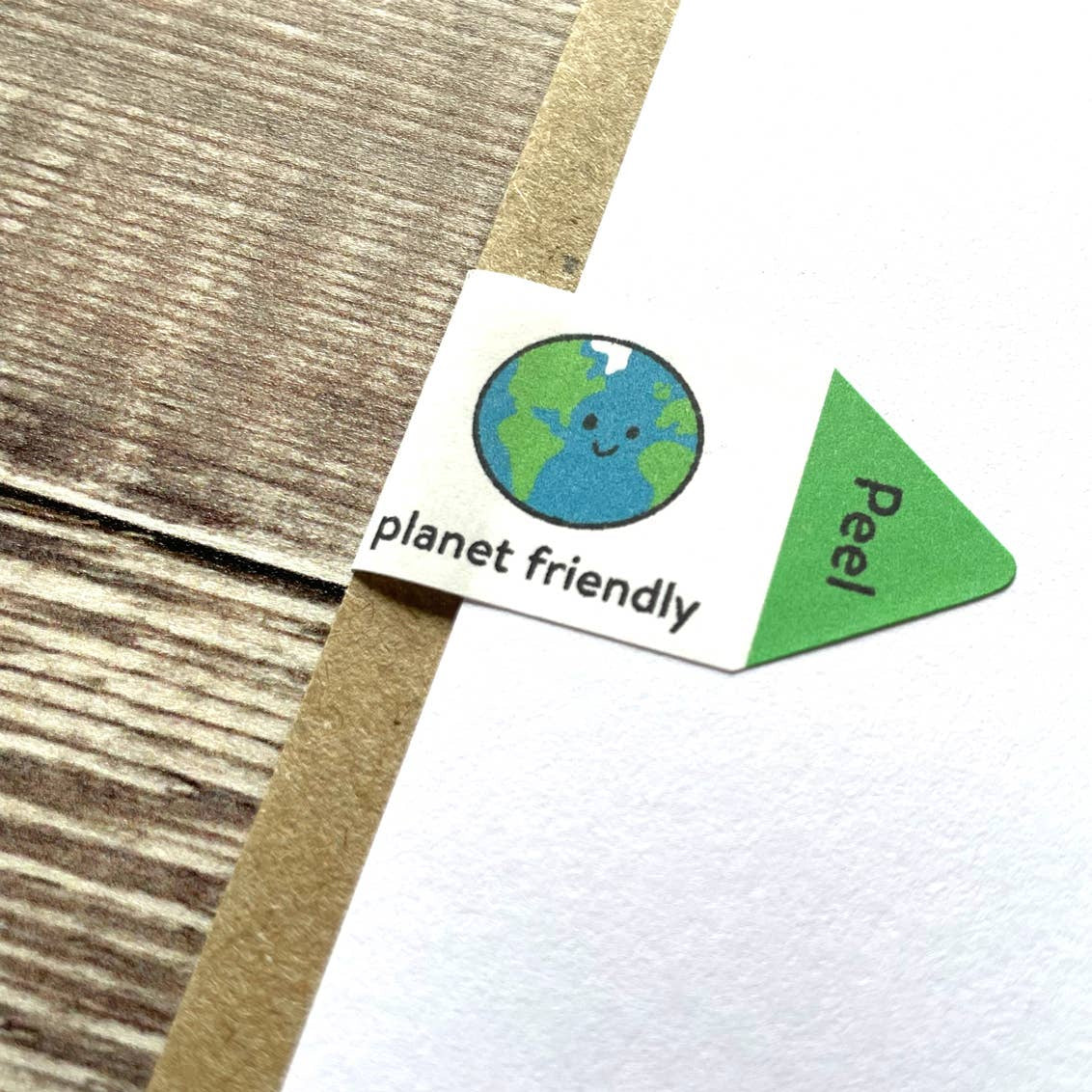 Planet friendly label on a white card on a textured wooden table