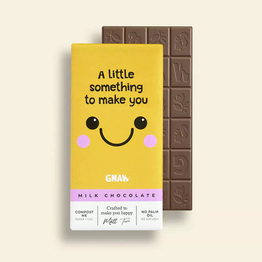 A yellow chocolate bar packaging with a cartoon smiley face and the text 'A little something to make you smile' alongside a milk chocolate label.