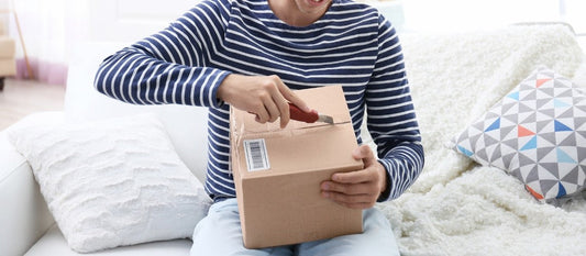 Box being opened on a sofa. Unboxing image