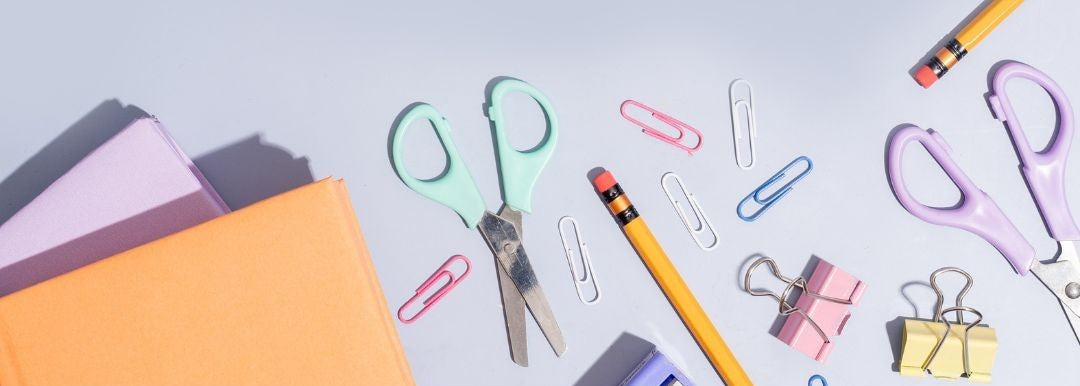 Pastel coloured stationery set including scissors, notebooks, pencils and paper clips – soft tones for stylish desk essentials.