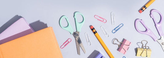 Pastel coloured stationery set including scissors, notebooks, pencils and paper clips – soft tones for stylish desk essentials.