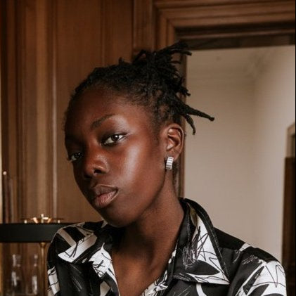 Woman in a monochrome outfit standing at a bar wearing the
MAD Ondulée Hoop handmade in Glasgow from recycled sterling silver – bold, wearable and exclusive in design
