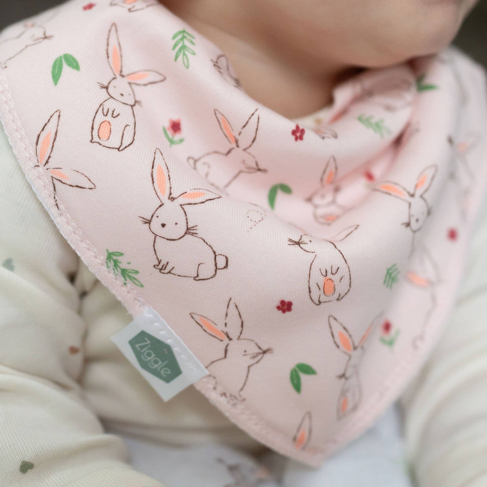 Baby wearing a bib with bunny pattern
