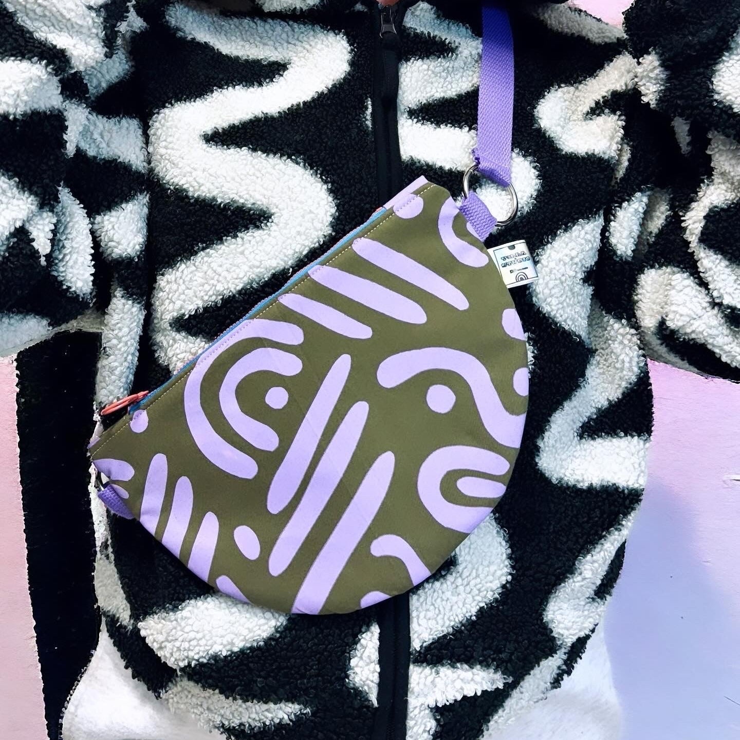 Handprinted crossbody bag handmade in Dundee from water-resistant wax cotton with padded lining, inner pocket and adjustable strap.