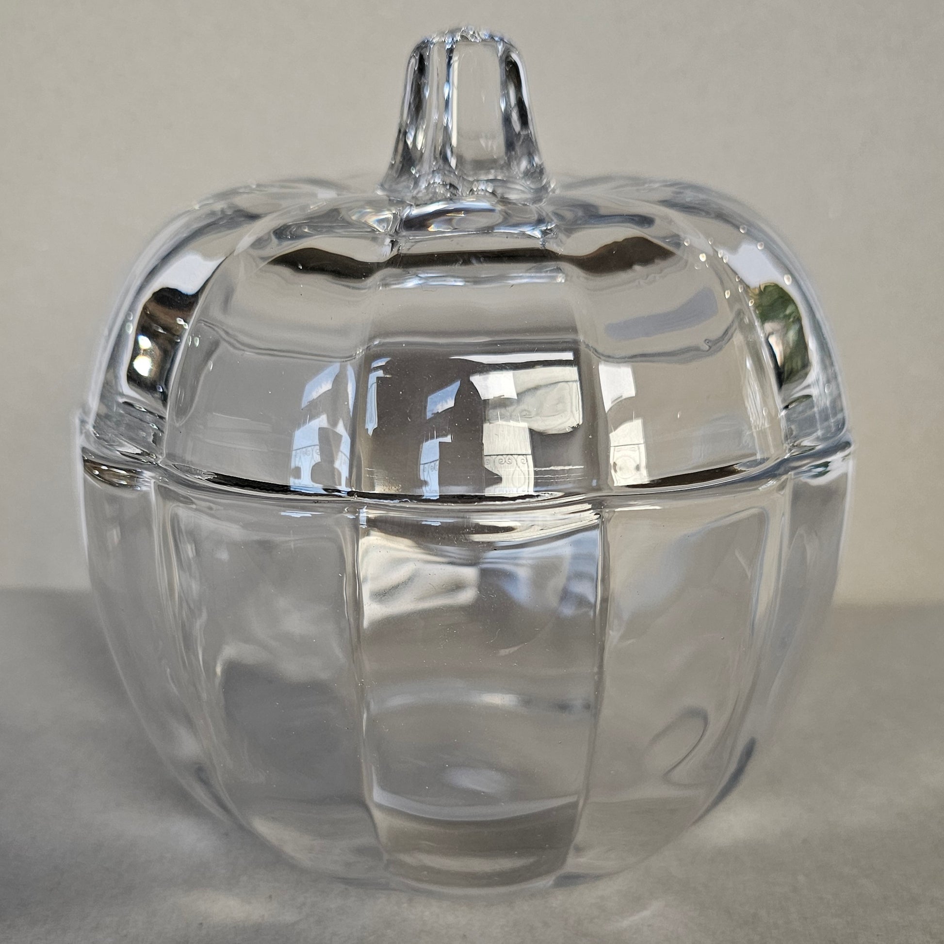Glass pumpkin-shaped jar, ideal for storage or autumn decoration.