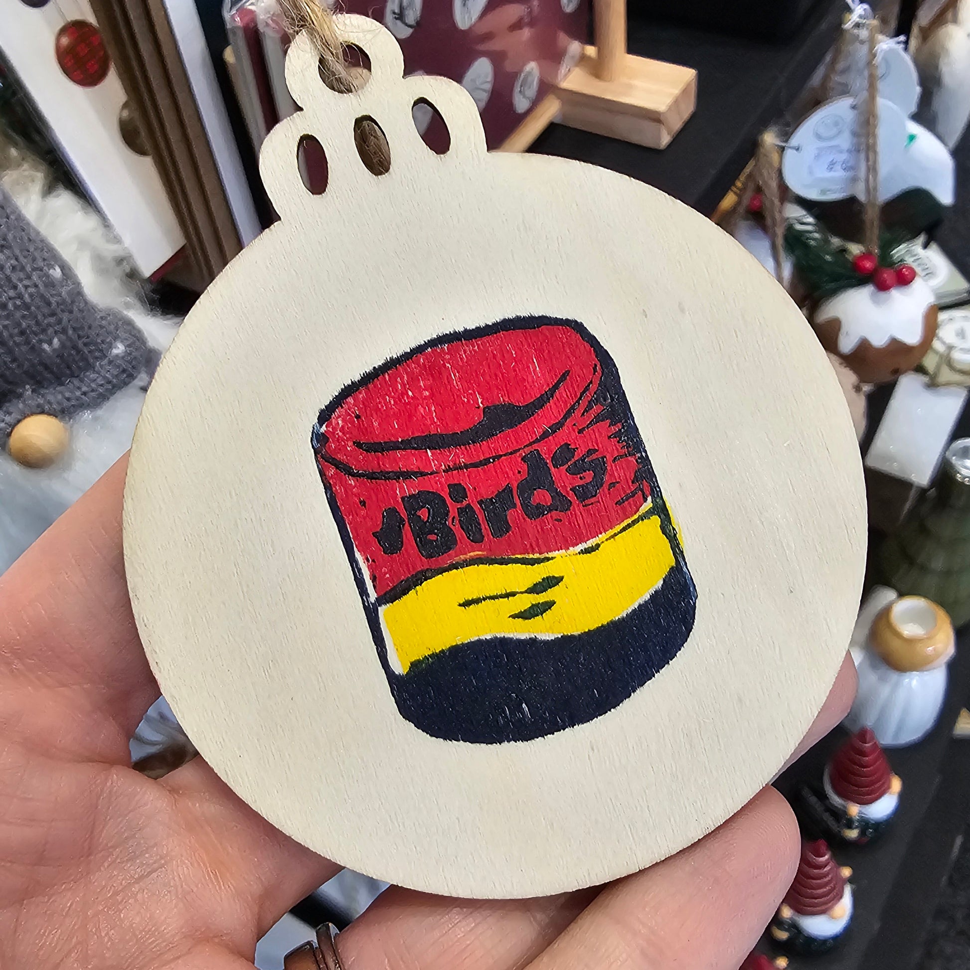 Small handprinted wooden Christmas tree decorations featuring custard design