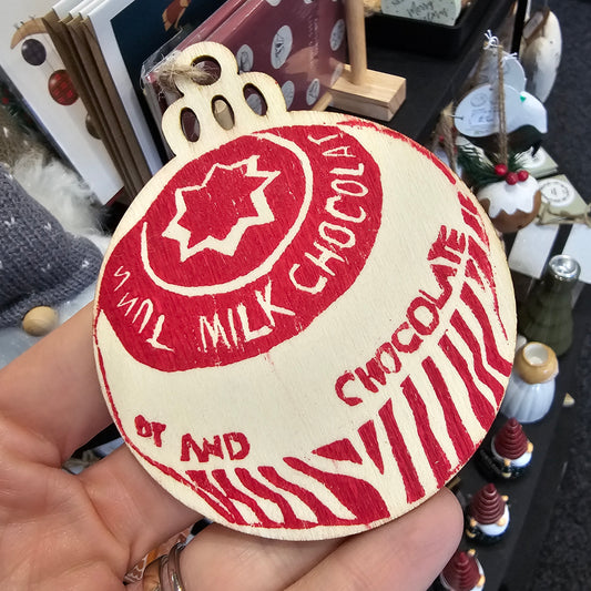 Small handprinted wooden Christmas tree decorations featuring teacake design