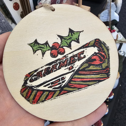 Small handprinted wooden Christmas tree decorations featuring caramel wafer design