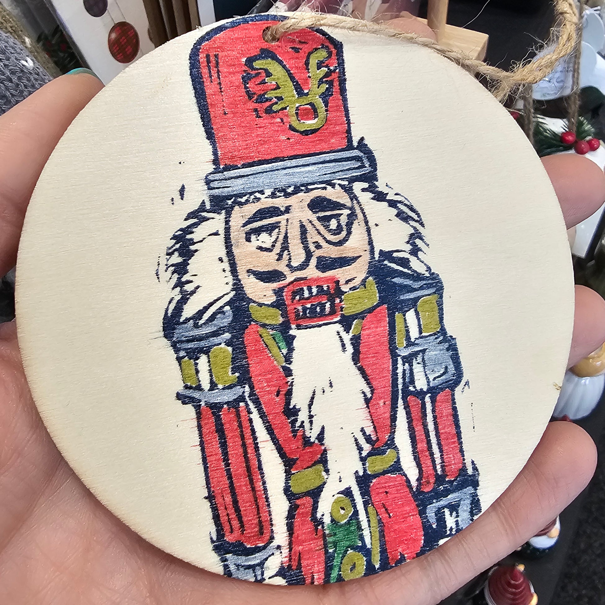 Small handprinted wooden Christmas tree decorations featuring nutcracker design