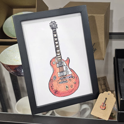 Colourful lino print artwork by Bee Birds titled 'Time Flies', featuring a design inspired by musical themes and an Oasis guitar.