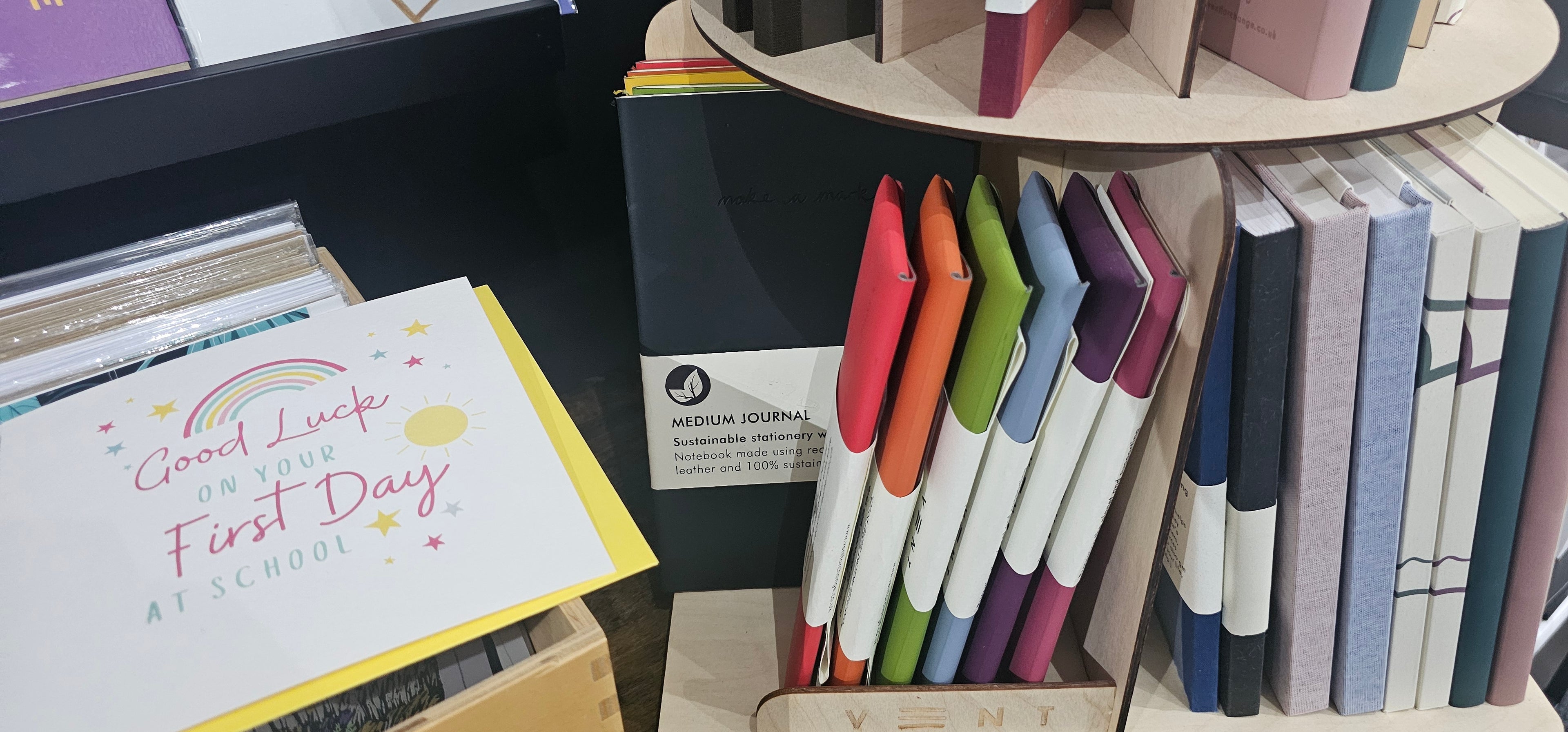 Desk with stationery items including notebooks, pens, and a greeting card.