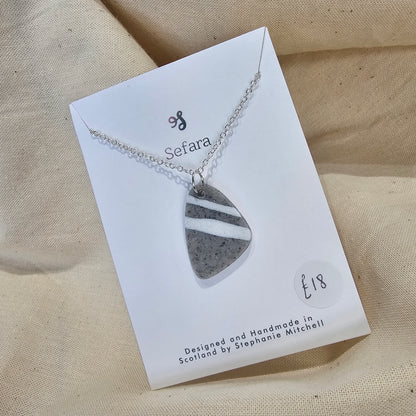 Handmade grey and white polymer clay pebble shaped pendant on 18-inch silver plated chain by Sefara Jewellery. Striped design.