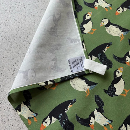 Fabric with puffin pattern on a green background