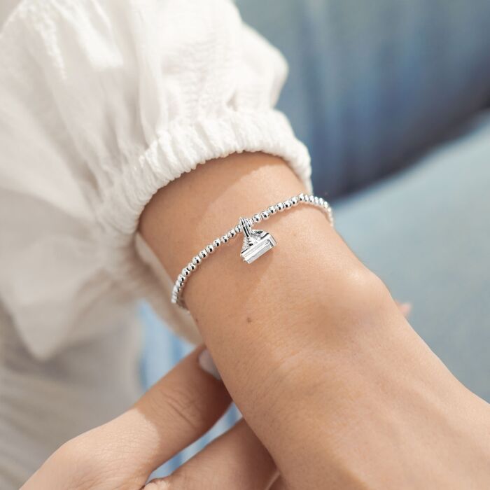 Silver-plated stretch beaded bracelet with cake shaped charm